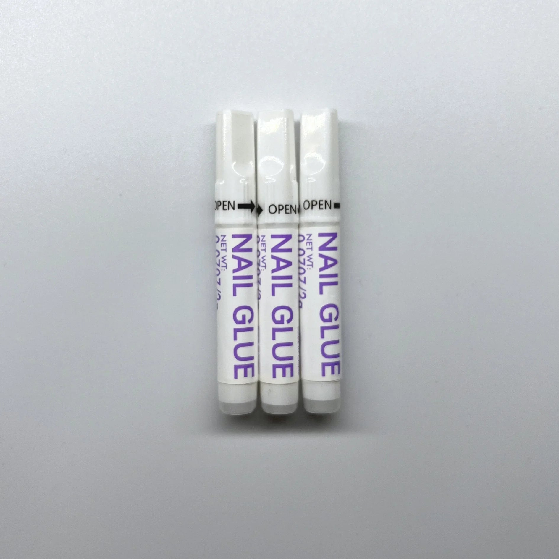 XGlue nagellim 3-pack – tre vita tuber Nail Glue för press-on naglar mot vit bakgrund