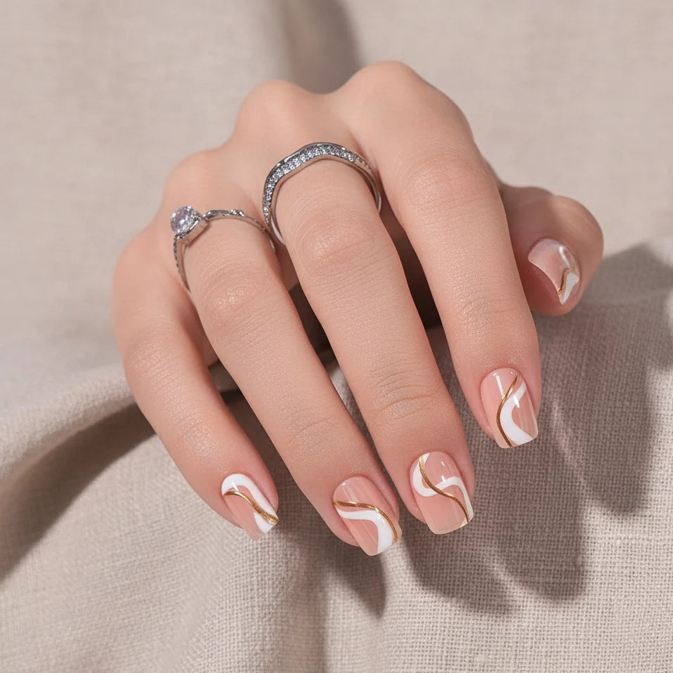 Summer Swirl square press-on negler nærbilde – gull og hvite swirls med sølvringer mot beige lin