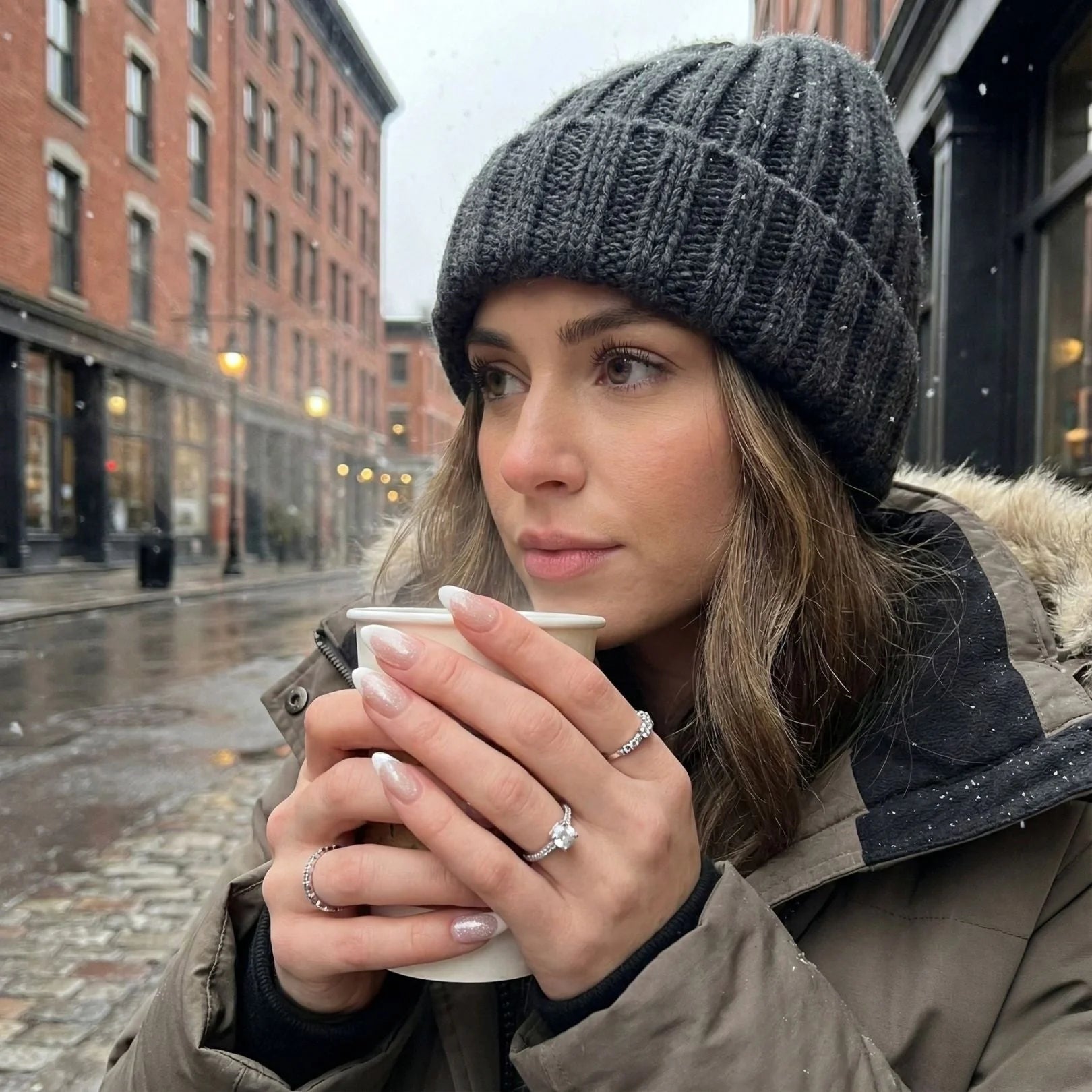 Sweet Sprinkle naglar lifestyle – mandelformade lösnaglar håller kaffekopp i grå beanie på snöig stadsgata