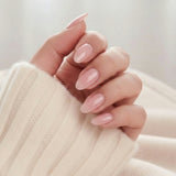 Pinkie Pearl press-on negler – delikat rosa pearl i mandelform mot kremfarget strikket genser