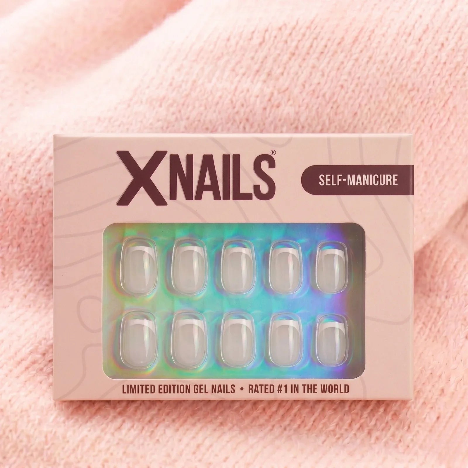 XNails-eske french frost short square press-on negler mot rosa strikket bakgrunn