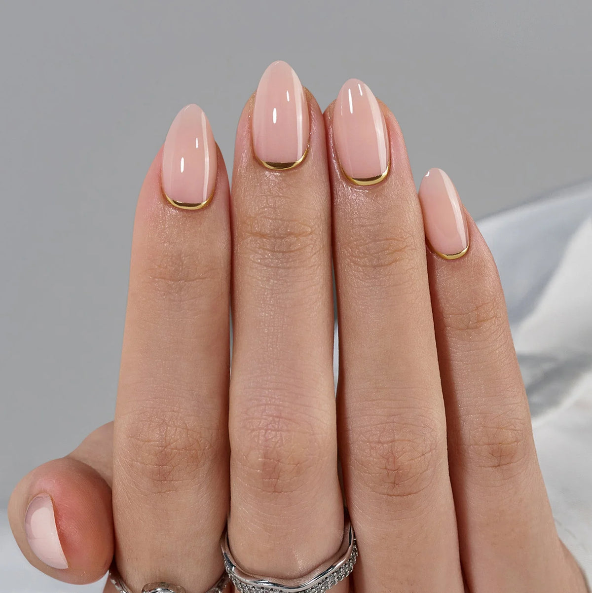 Golden Glimmer press-on negler nærbilde – nude base og gull linje langs cuticle