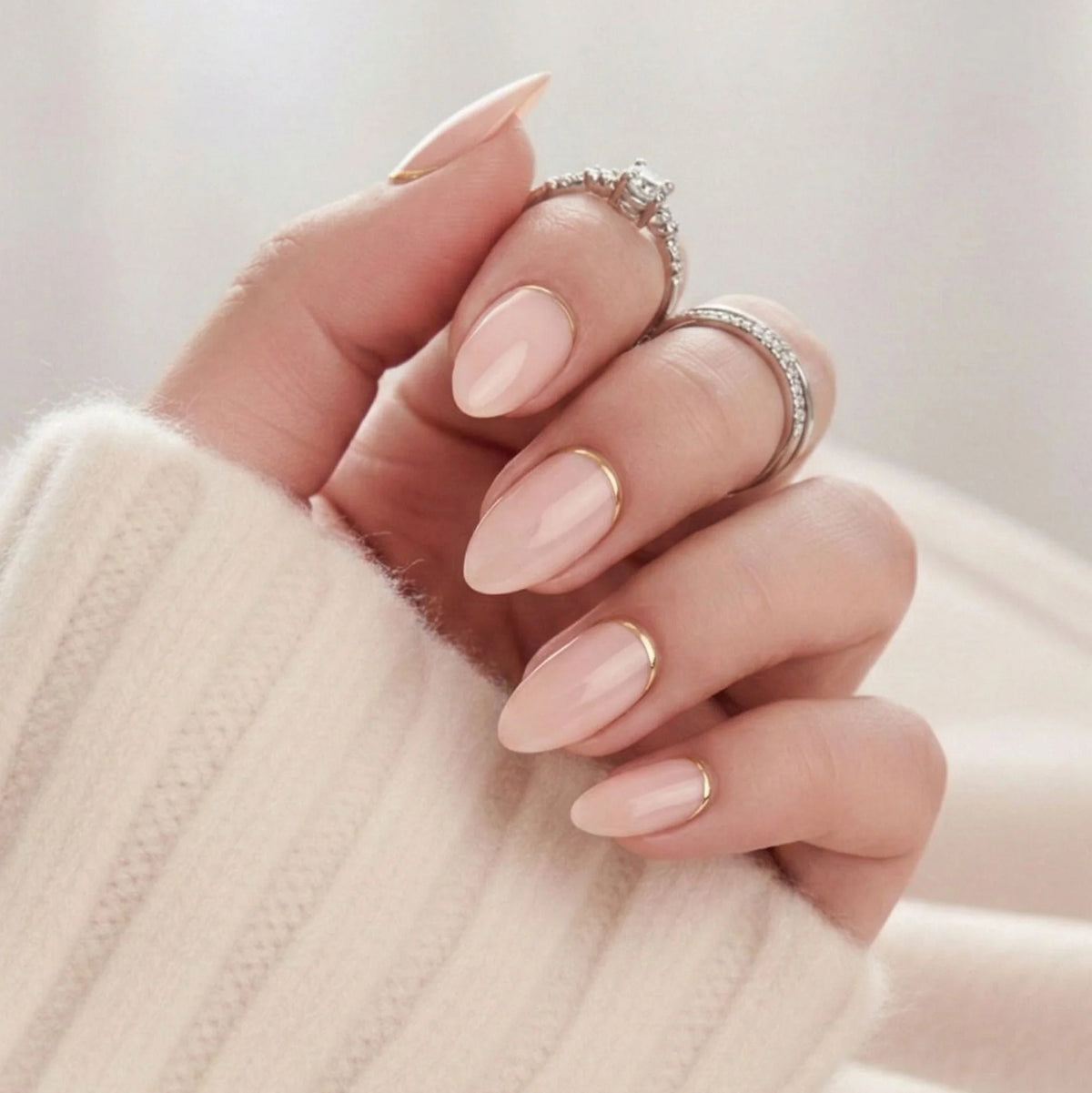 Golden Glimmer press-on negler – nude mandelform med tynn gulllinje langs buen