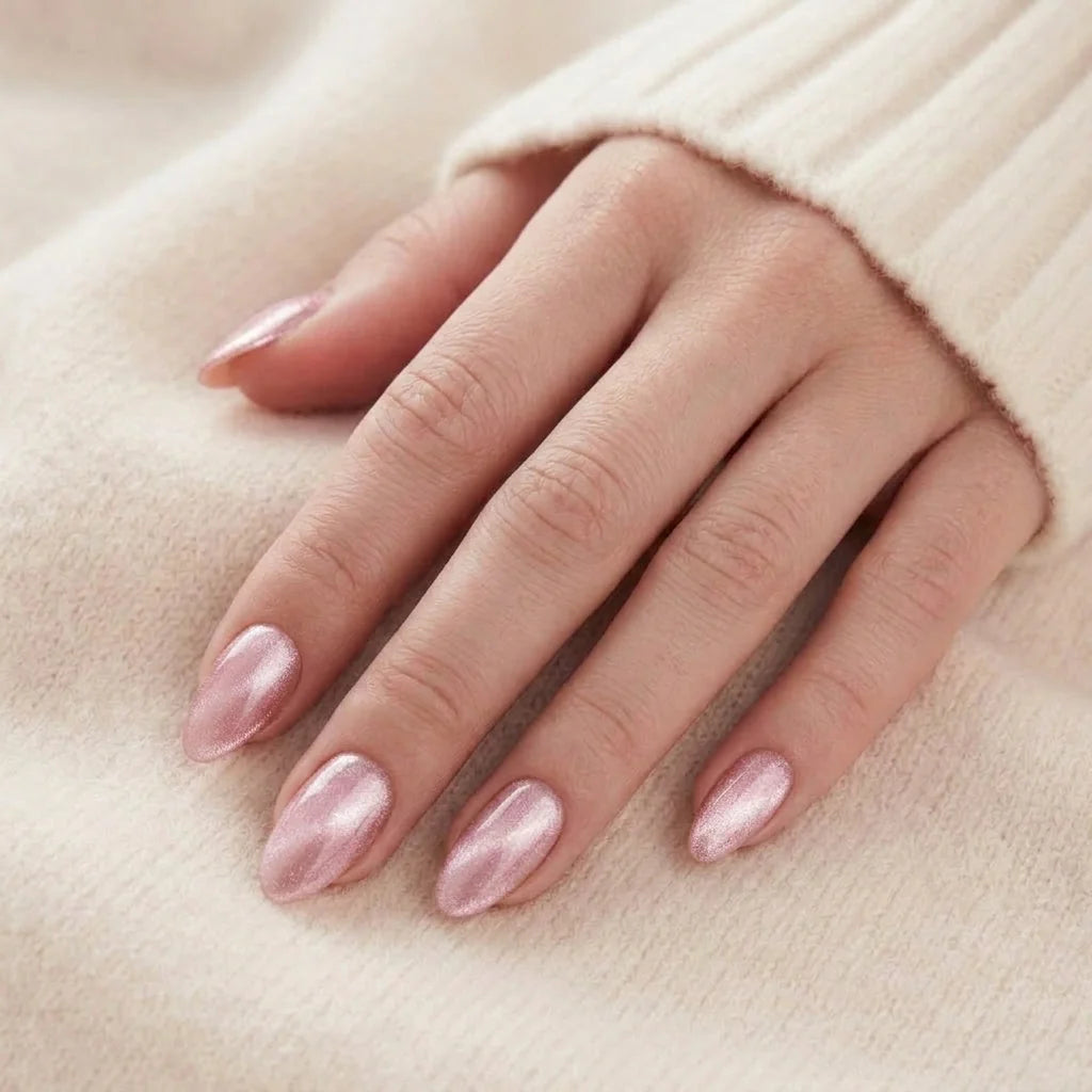 Powder Puff løsnegler nærbilde – rosa chrome mandelformete gelénegler mot myk beige strikket bakgrunn