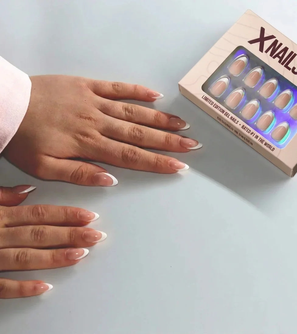 To hender med franske press-on negler ved siden av den beige XNails-esken