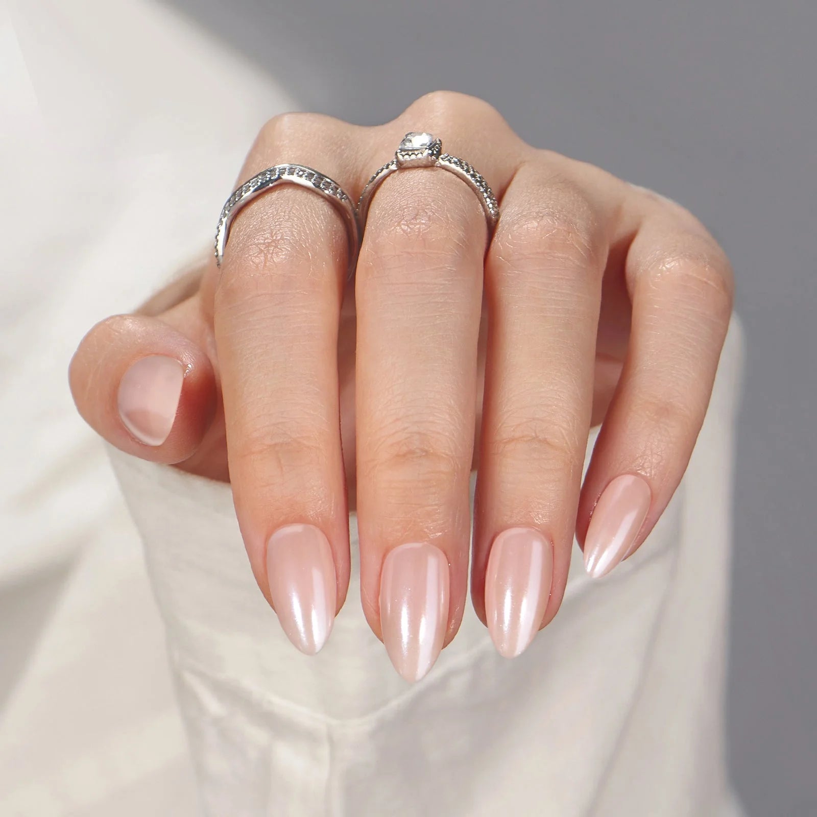 Heavenly Halo press-on negler nærbilde – blank pearl finish med sølvringer og hvit bluse