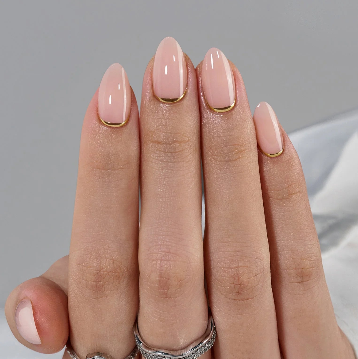 Golden Glimmer press-on negler nærbilde – nude base og gull linje langs cuticle
