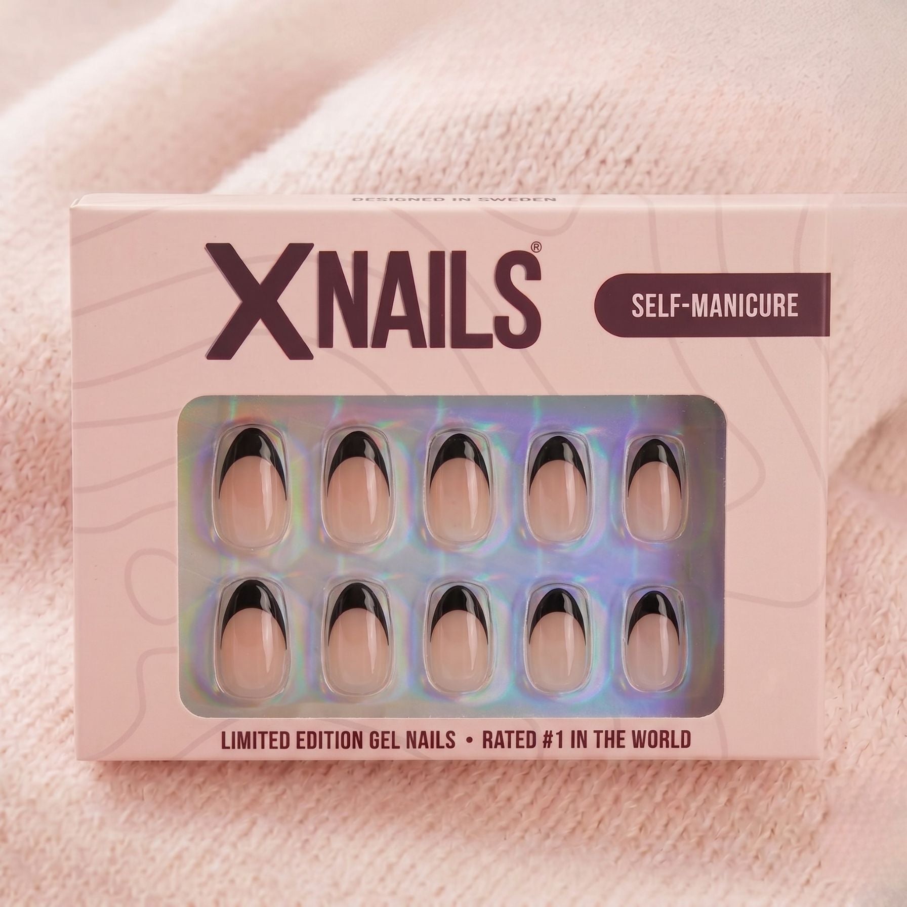 Sleek Silhouette XNails eske – limited edition gelenegler i mandelform med svart fransk tipp mot beige strikket bakgrunn