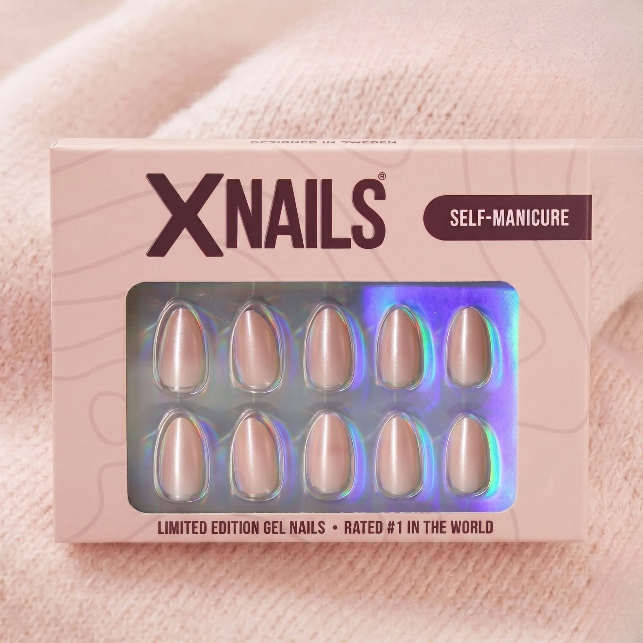 XNails-eske med sølv chrome almond press-on negler mot rosa strikket bakgrunn