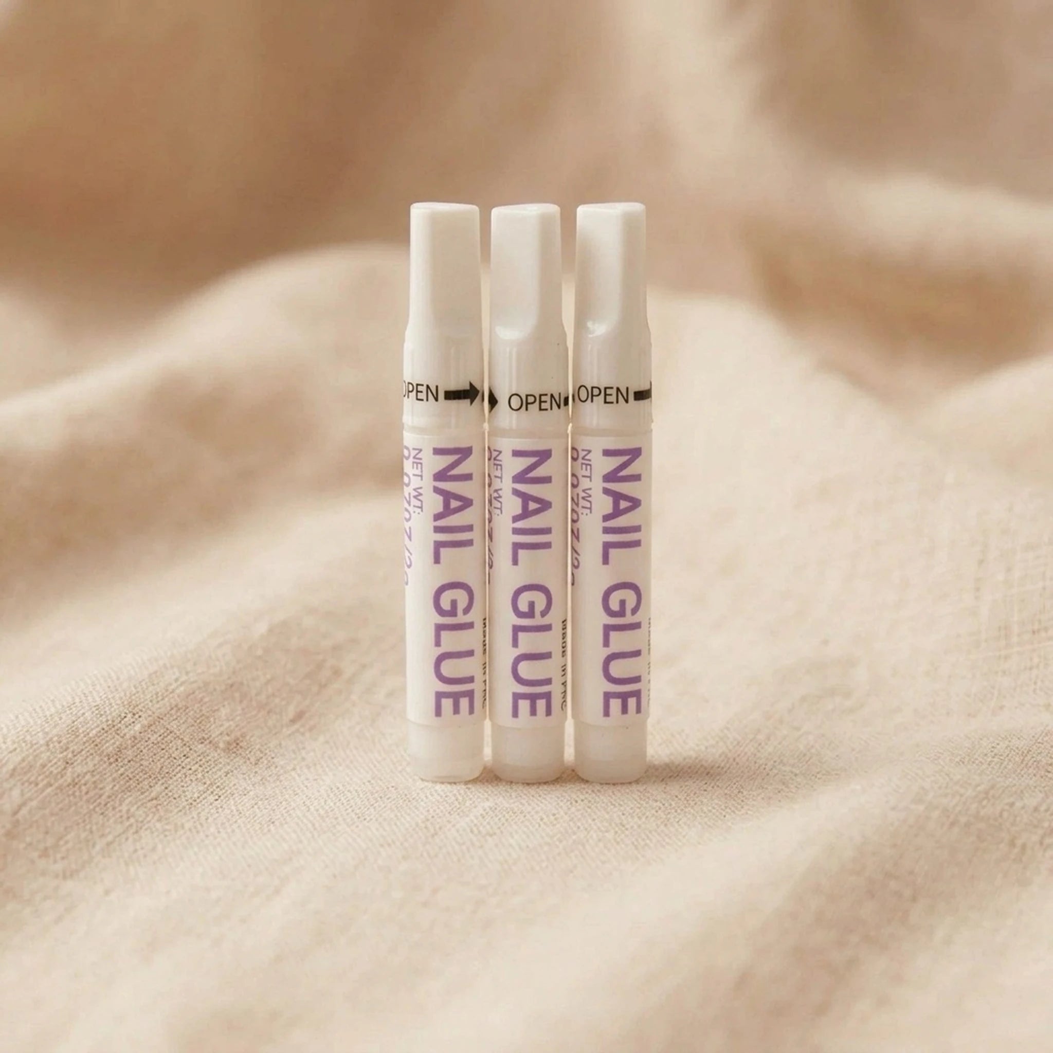 XNails Nail Glue neglelim på beige bakgrunn