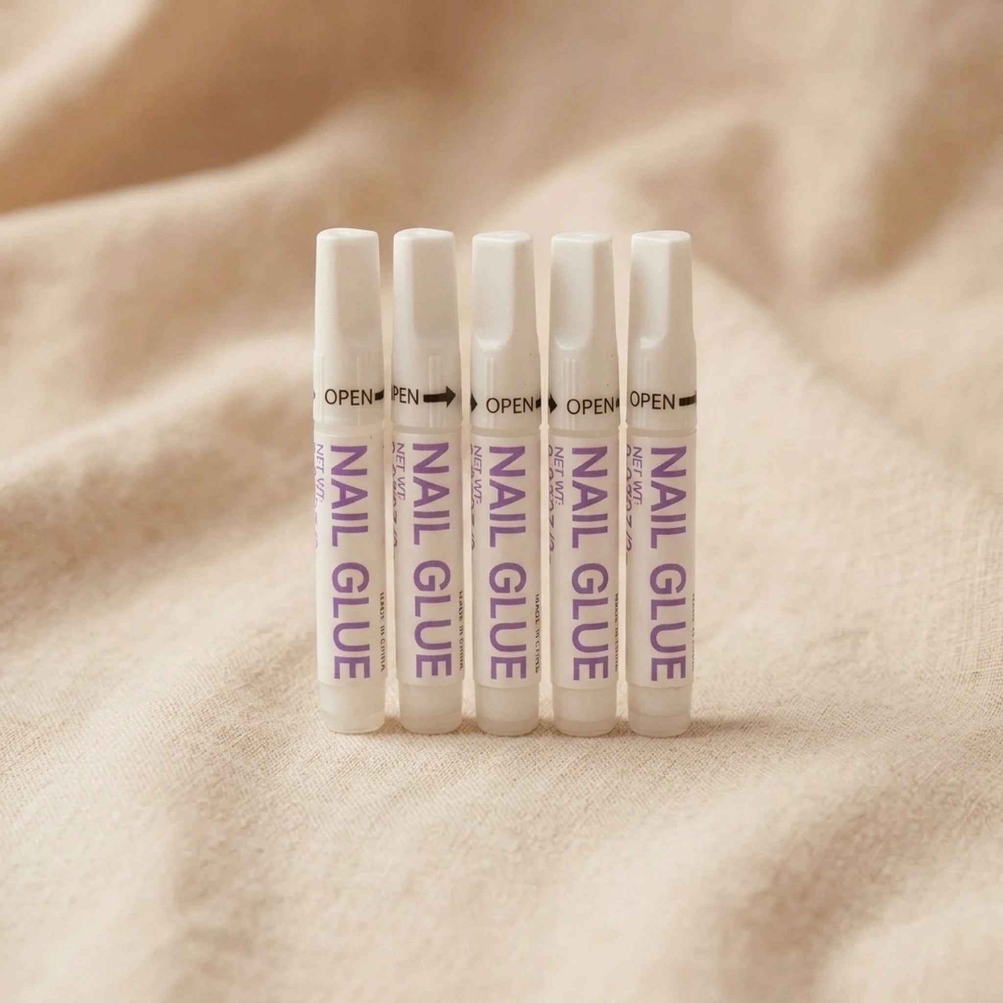 XNails Nail Glue neglelim på beige bakgrunn