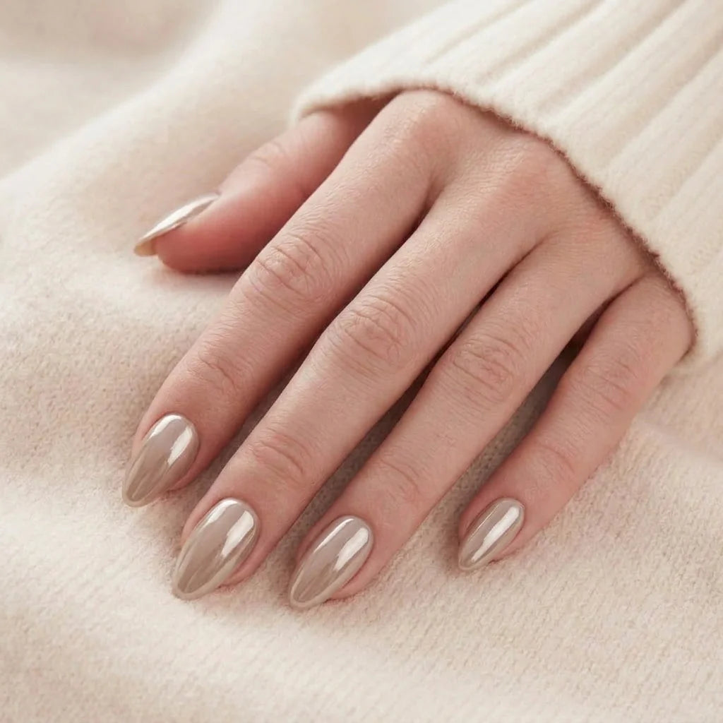 Pearly Perfection negler på hånd – mandelformete gelénegler i perlemor taupe hviler mot beige genser