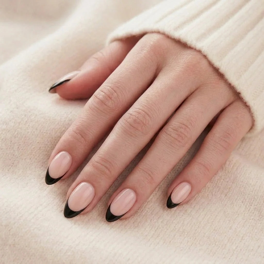 Sleek Silhouette løsnegler nærbilde – nude mandelformete gelenegler med svart french-tipp på beige bakgrunn